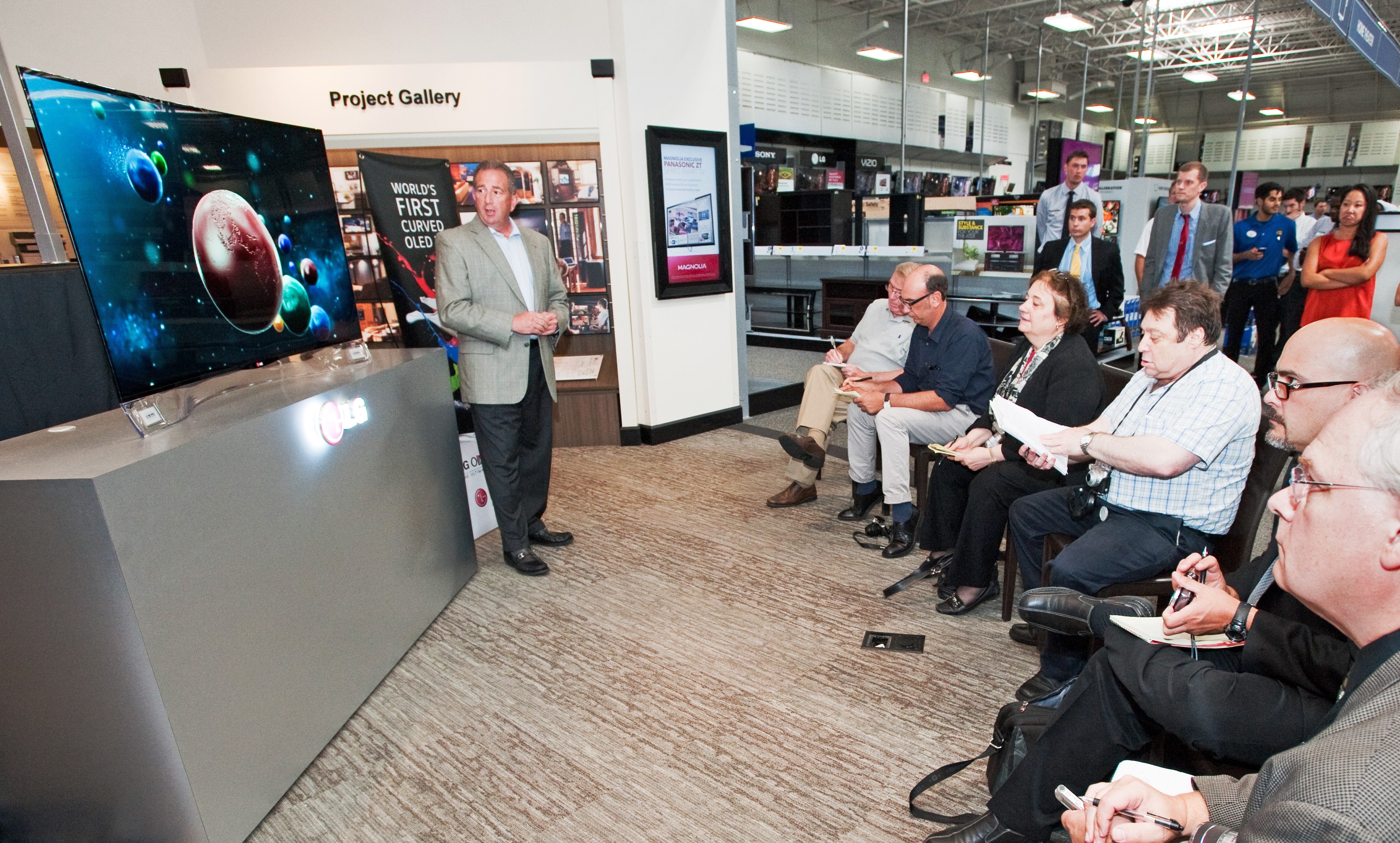 An LG representative demonstrates LG’s CURVED OLED TV model 55EA9800 to attendees