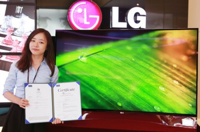 An LG representative holds up the green certificate given by three certification bodies, including Intertek, the European Commission and the Electronic Product Environmental Assessment Tool, while standing in front of LG’s Curved OLED TV