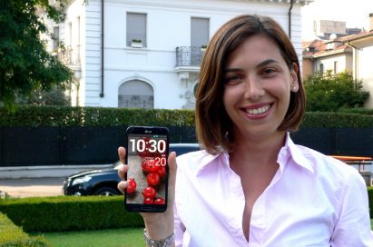 A woman posing in a garden holding the LG Optimus G Pro.