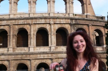 A woman posing in front of the Colosseum, Italy, while holding the LG Optimus G Pro.