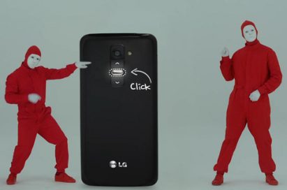 A wallpaper of the Play & Share LG G2 campaign – a back view of a gigantic LG G2 between two men wearing red body suits.