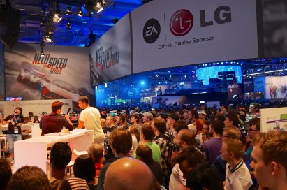 Staff at LG and EA’s stage interview a visitor while others watch on at Gamescom 2013