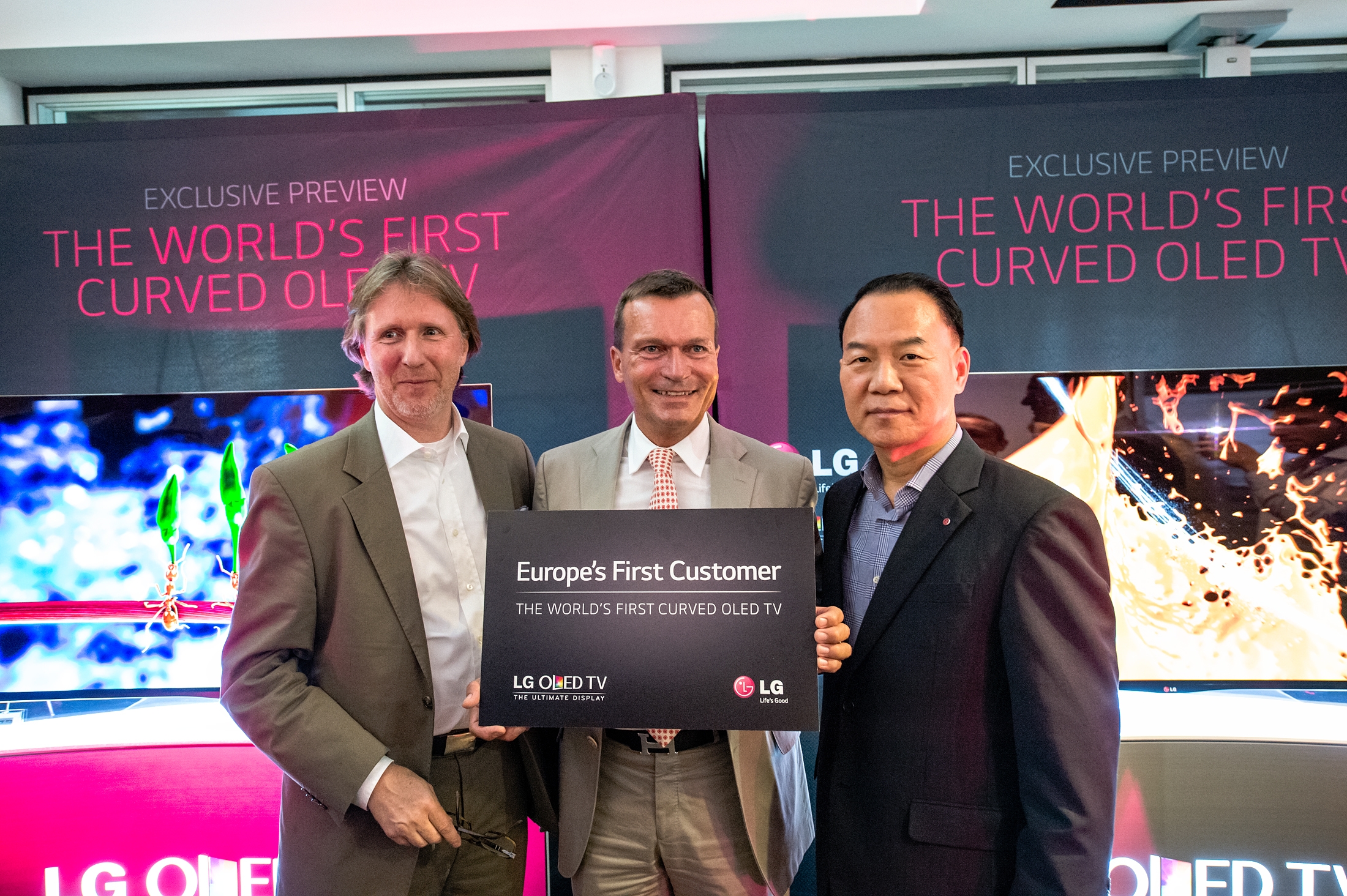 An LG representative and two German market representatives posing for the camera at the exclusive preview of the world’s first curved OLED TV.