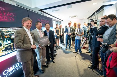 An LG representative and two German market representatives posing for the camera at the exclusive preview of the world’s first curved OLED TV.