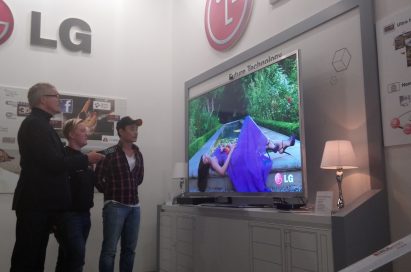 Three visitors watching LG’s comprehensive lineup of set-top boxes in LG’s International Broadcasting Convention booth