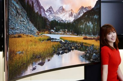 A model leans on the edge of LG 21:9 aspect ratio CURVED ULTRA HD TV model 105UC9 at CES 2014