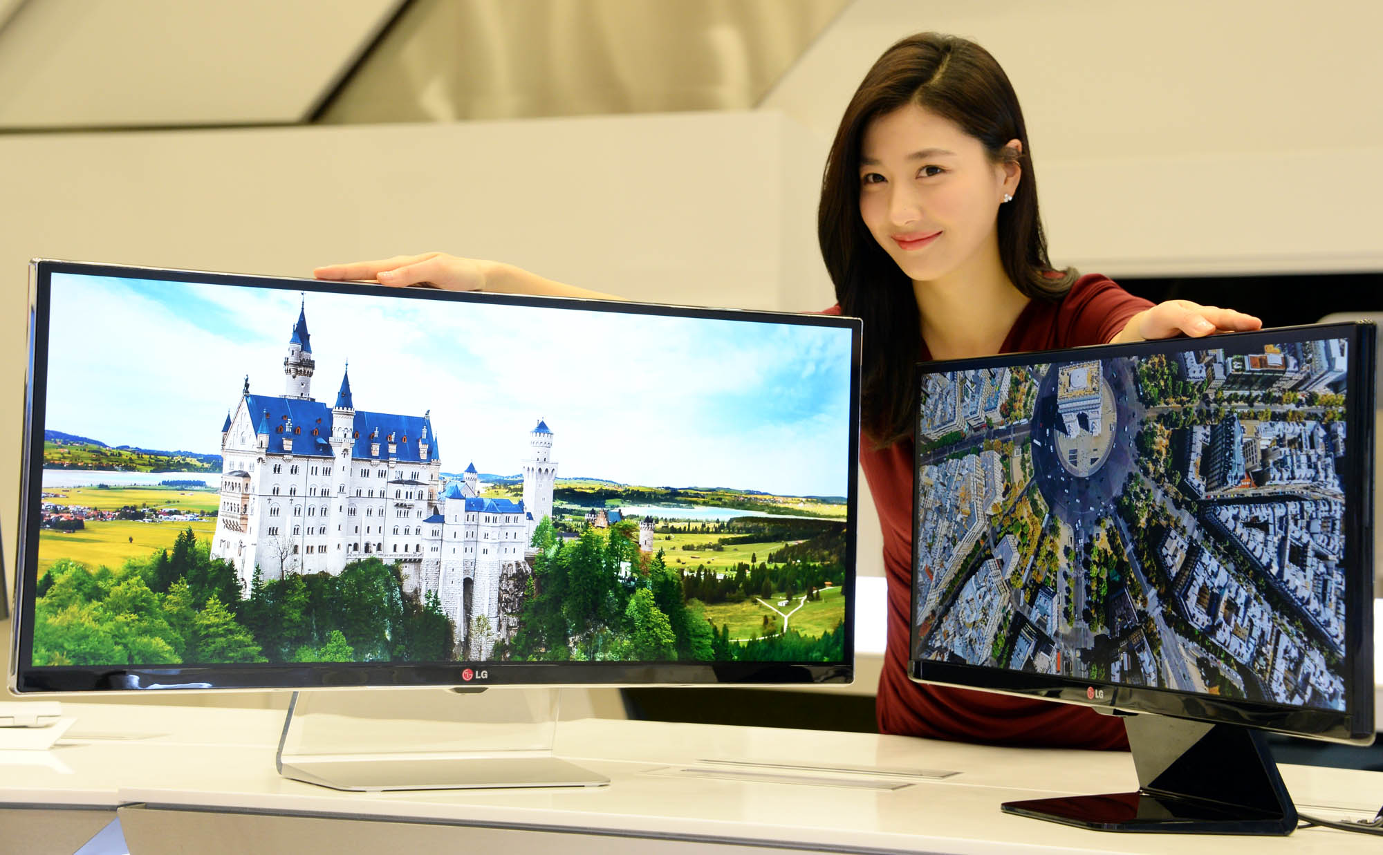 A model presenting the 34-inch and 29-inch IPS 21:9 UltraWide monitors while putting her hands on both