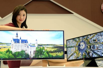 A model presenting the 34-inch and 29-inch IPS 21:9 UltraWide monitors while leaning on the 34-inch model