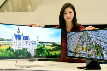 A model presenting 34-inch and 29-inch IPS 21:9 UltraWide monitors while putting her hands on both