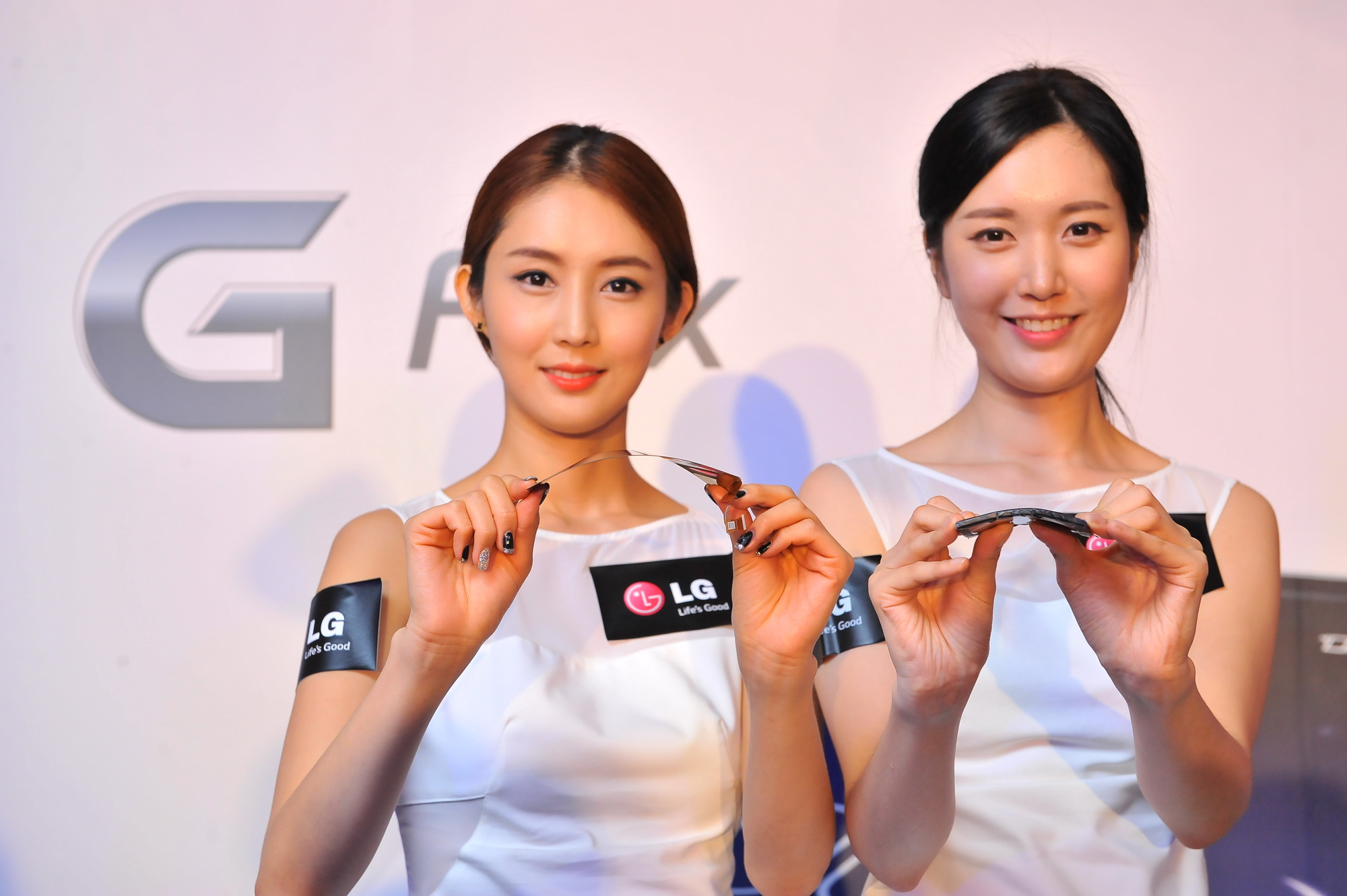From left to right; two models are showing how the P-OLED HD display of LG G Flex and the LG G Flex are curved.