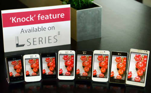 A panel saying “’Knock’ feature Available on SERIES” is standing on a table in front of various LG smartphones.