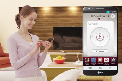 A woman using her phone to remotely control LG HOM-BOT