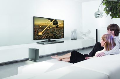 Two models watching TV on the LG SoundPlate model LAB540 while enjoying an impressive sound experience