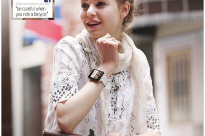 A woman wearing the LG G Watch in White Gold rides her bicycle, with a screenshot of the watch’s displaying Facebook comments such as, “be careful when you ride a bicycle.”