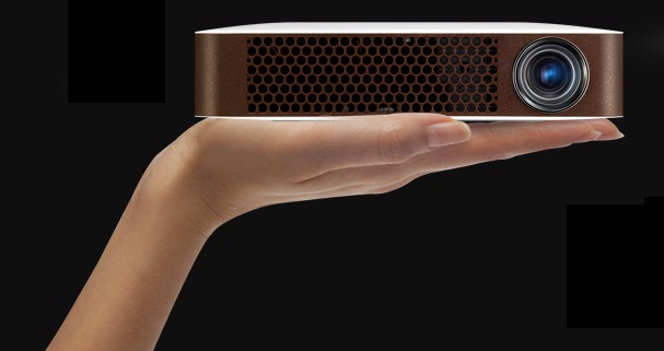 A model holds LG’s bluetooth MiniBeam projector with one hand to prove mobility of the product.