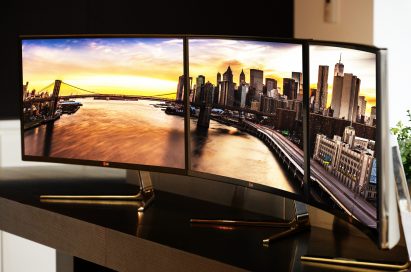Three LG Curved Ultrawide Monitors 34UC97 put together on a desk to create one giant screen