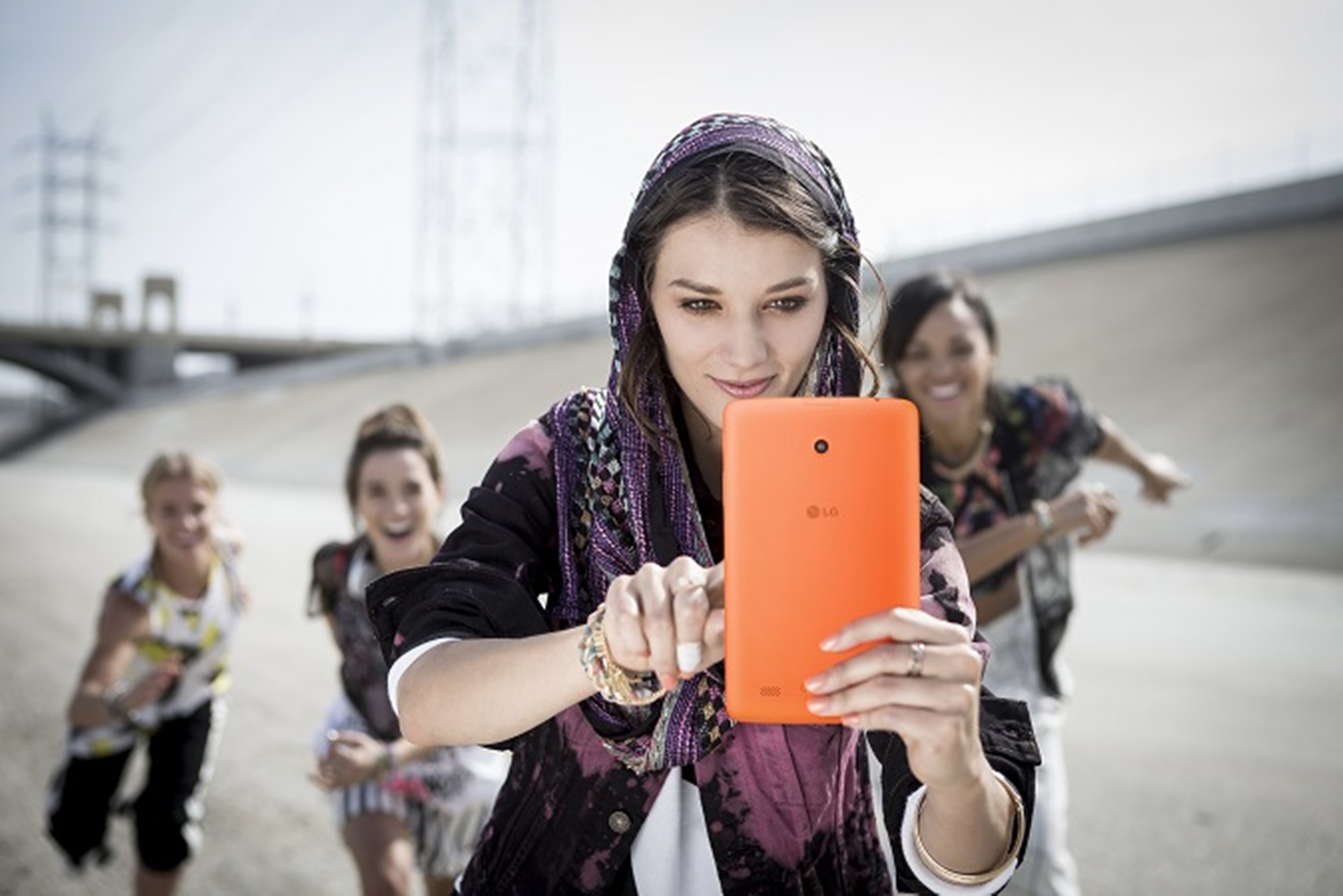 A woman and 3 kids are taking selfies with a LG G Pad 8.0 LTE.