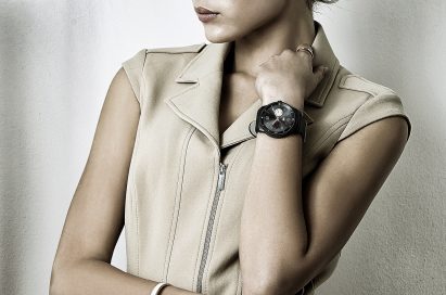 A woman is leaning on her elbow wearing a LG G Watch R.