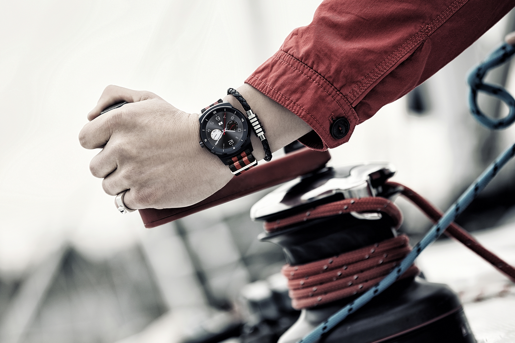 A man wearing the LG G Watch R as he loosens ropes.
