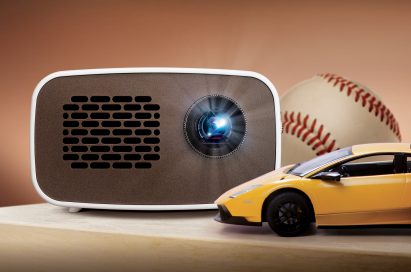 Front view of LG HD MiniBeam model PH300 beaming light on a table next to images of a baseball and supercar