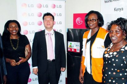 People from LG and World Vision Kenya standing in front of the LG solar powered refrigerator equipped with Smart Inverter Compressor