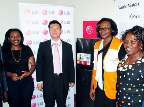 People from LG and World Vision Kenya standing in front of the LG solar powered refrigerator equipped with Smart Inverter Compressor