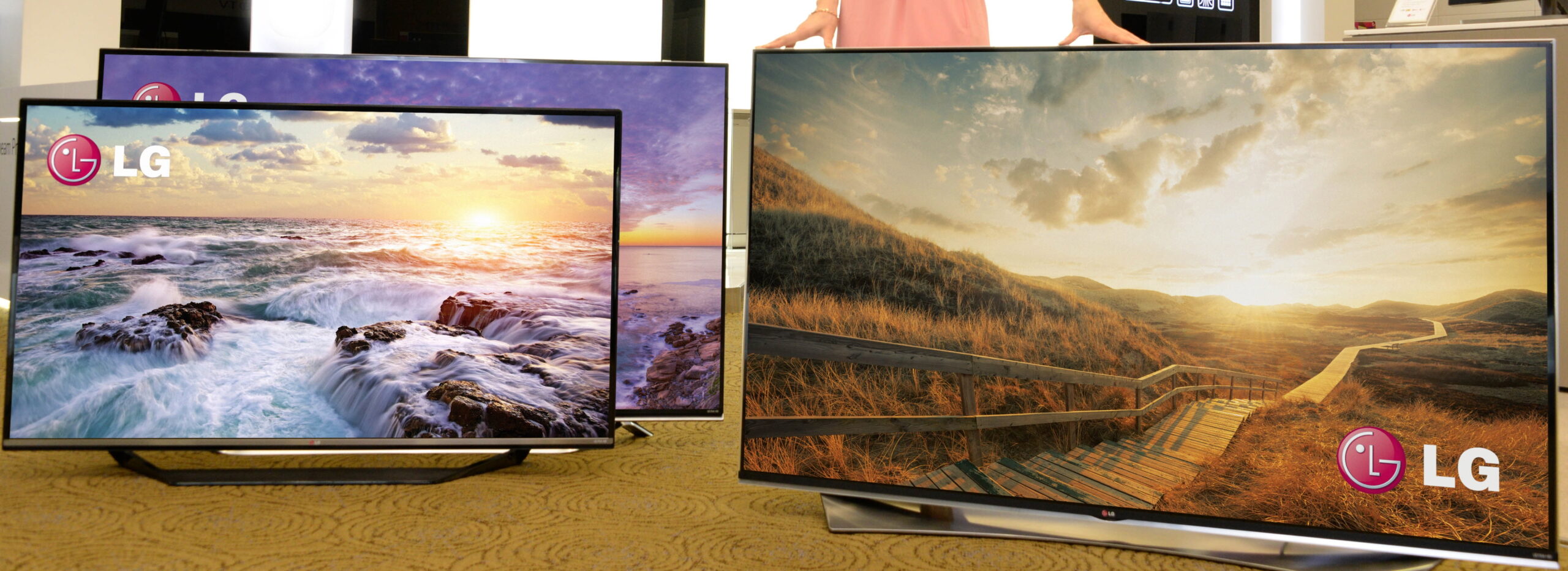 Two side-by-side LG 4K ULTRA HD TVs in the front of another LG TV