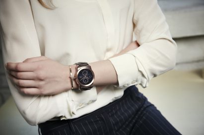 A woman folding her arms while wearing the LG Watch Urbane in gold.