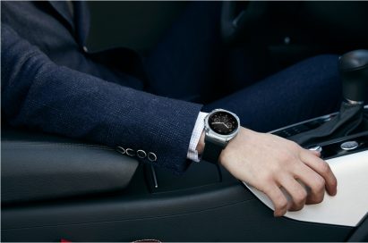 A side view of a man sitting in the driver’s seat while wearing the LG Watch Urbane LTE.