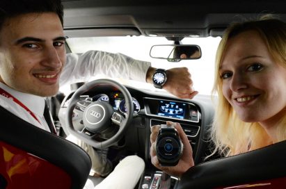 Two models sit in a car, the man wearing the LG Watch Urbane and woman holding one while posing for the camera
