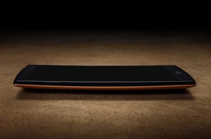 A side vie of the LG G4 wearing a brown leather when lying on a table.