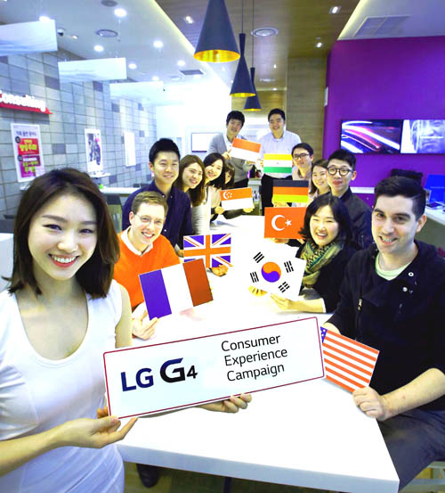A group of people from all around the world sit around a table behind a model holding up a “LG G4 Consumer Experience Campaign” sign.
