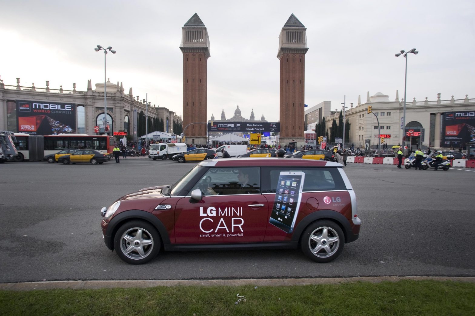 The LG Mini car drives past the Venetian Towers at Plaza España, Barcelona.