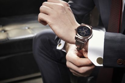 A man in suit tidies up the sleeve while wearing LG's Watch Urban.