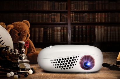 Front view of LG MiniBeam Nano sitting on desk in a dark room