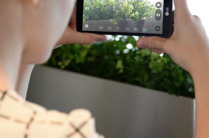 A woman taking a landscape picture with the LG G4 Beat.