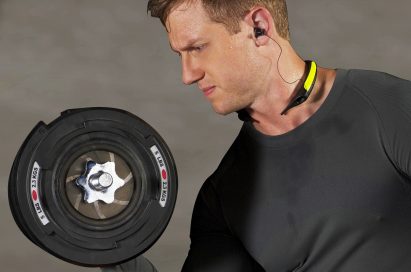 A man working out with a dumbbell while wearing the LG TONE Active.