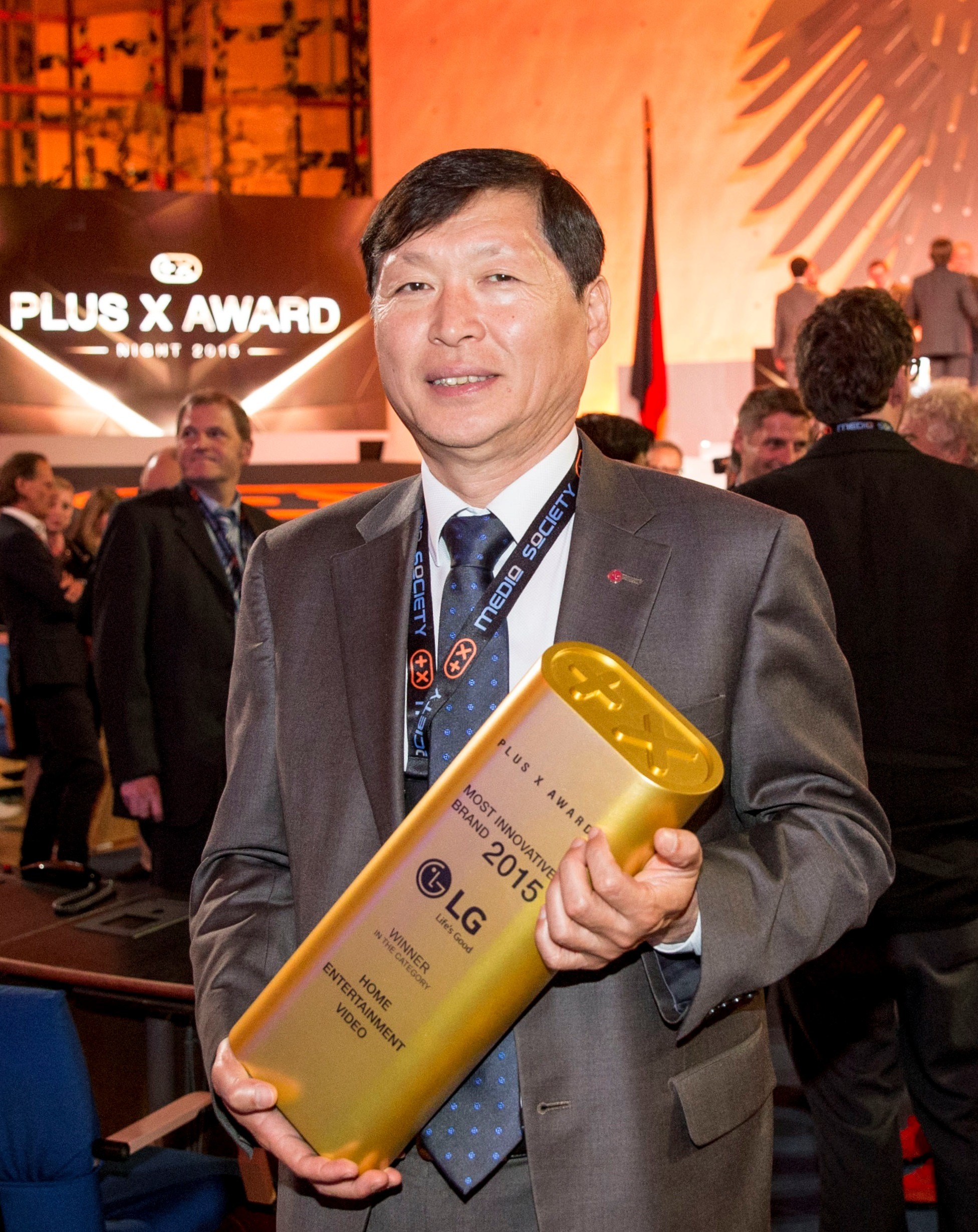 LG Germany president, Young Woong Lee, holding up the Most Innovative Brand of the Year award at the Plus X Awards ceremony
