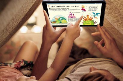 Two children lying in their bedroom tent while using LG Pad II 10.1, the boy holding the tablet as his sister points at pictures on the screen.