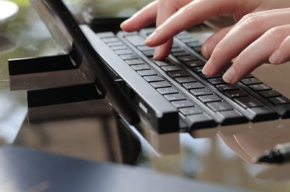 A woman typing with the Rolly Keyboard.