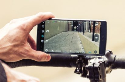 A person records a video on LG V10 propped on top of bicycle handles