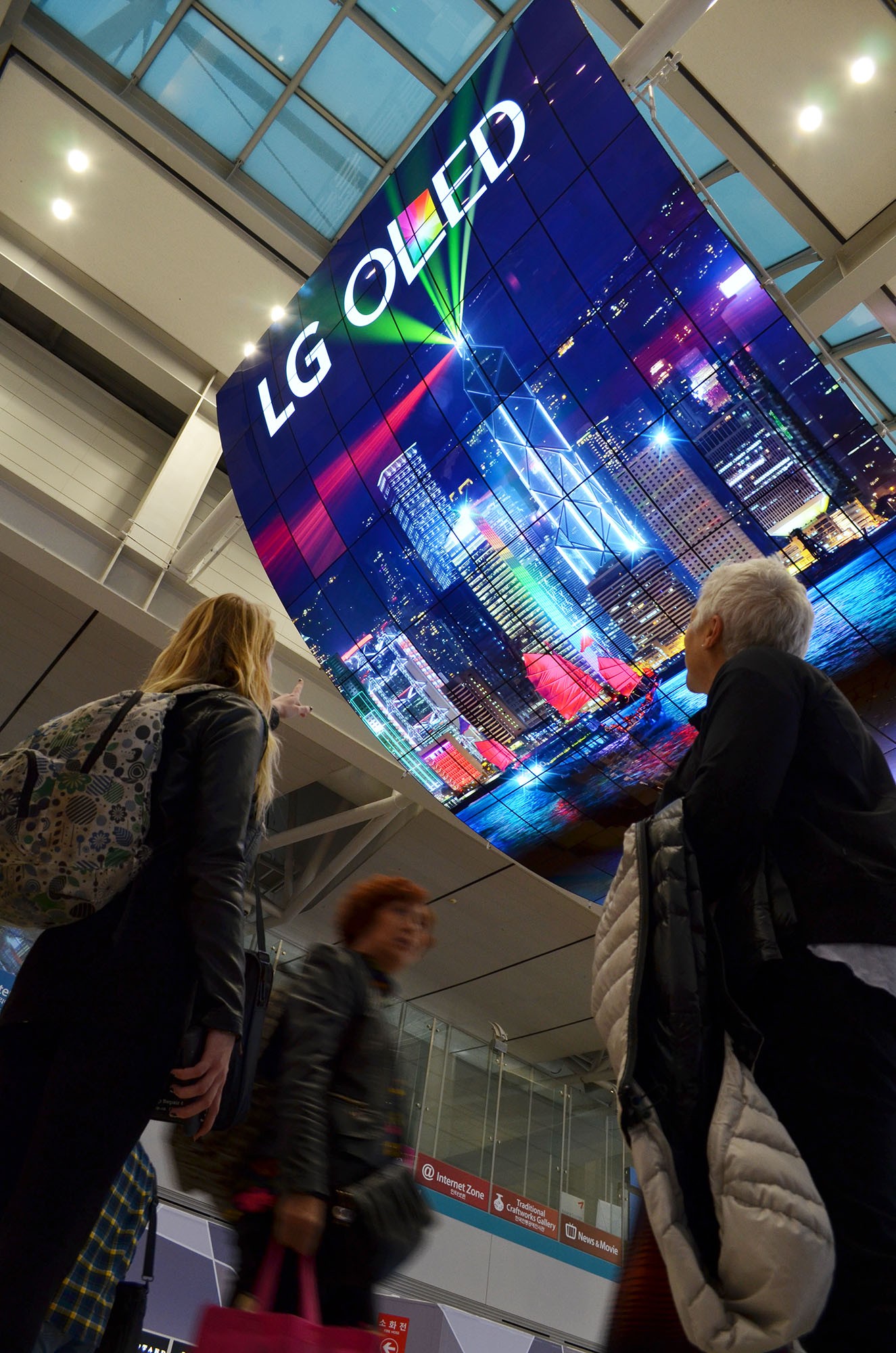 A ceiling installation of LG OLED Signage displaying a city’s skyline at night on display at Incheon International Airport