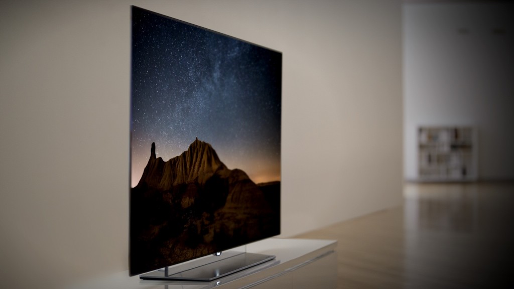 A left-side view of an LG OLED TV displaying a mountain scene at night.