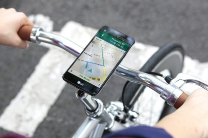 A biker is receiving directions from the LG X screen, which is fixed on the top of the bike handle