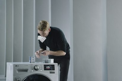 A professional card stacker Bryan Berg building house of card atop an LG Centum System™ washing machine