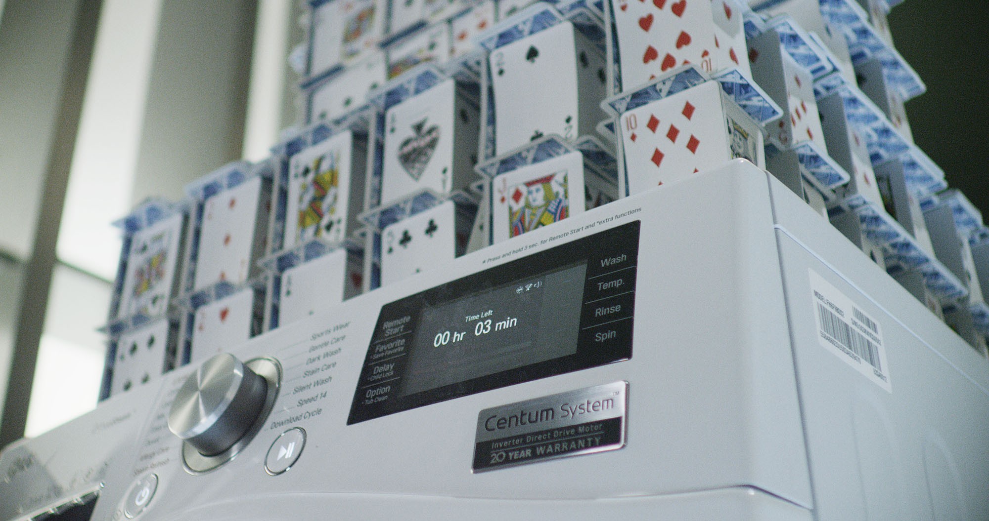 Closeup of LG Centum System™ washing machine and house of card built on it