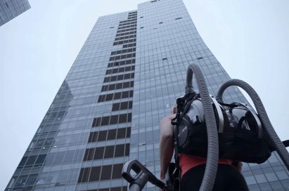 Professional rock climber Sierra Blair-Coyle with LG CordZero™ canister vacuum standing in front of 33-story office tower