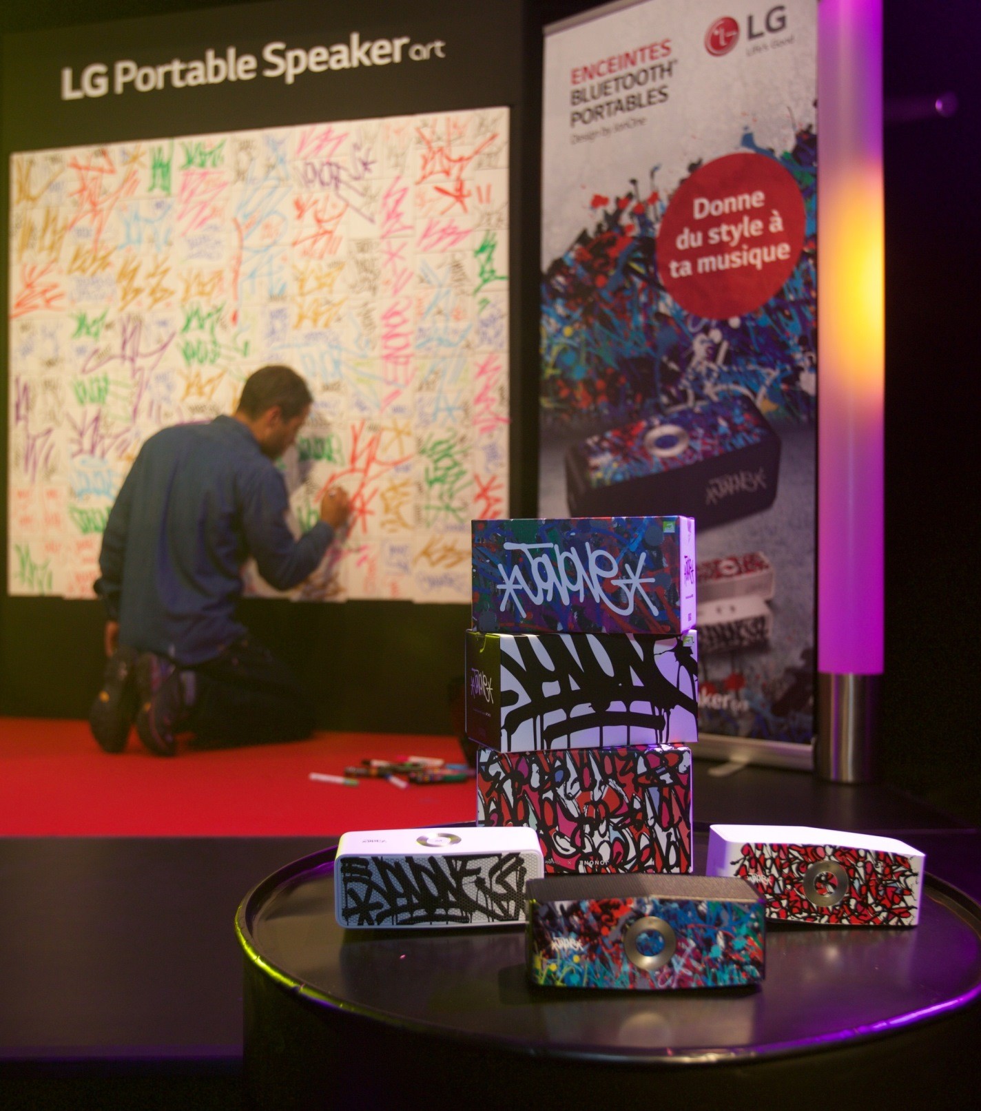 LG Portable Speaker artwork displayed in front with JonOne creating a new design on the wall in the background