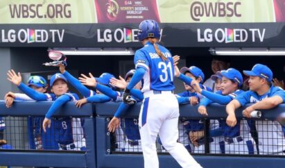 South Korean player hi-fives teammates in dugout with LG OLED TV logo in background