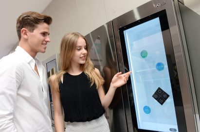 Women touching InstaView’s transparent glass panel and man staring at it
